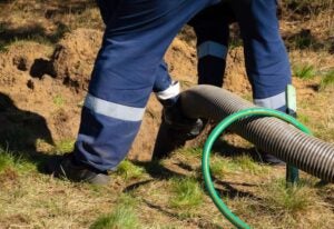 Technician Inspecting and Maintaining a Residential Septic Tank System in Jacksonville, FL