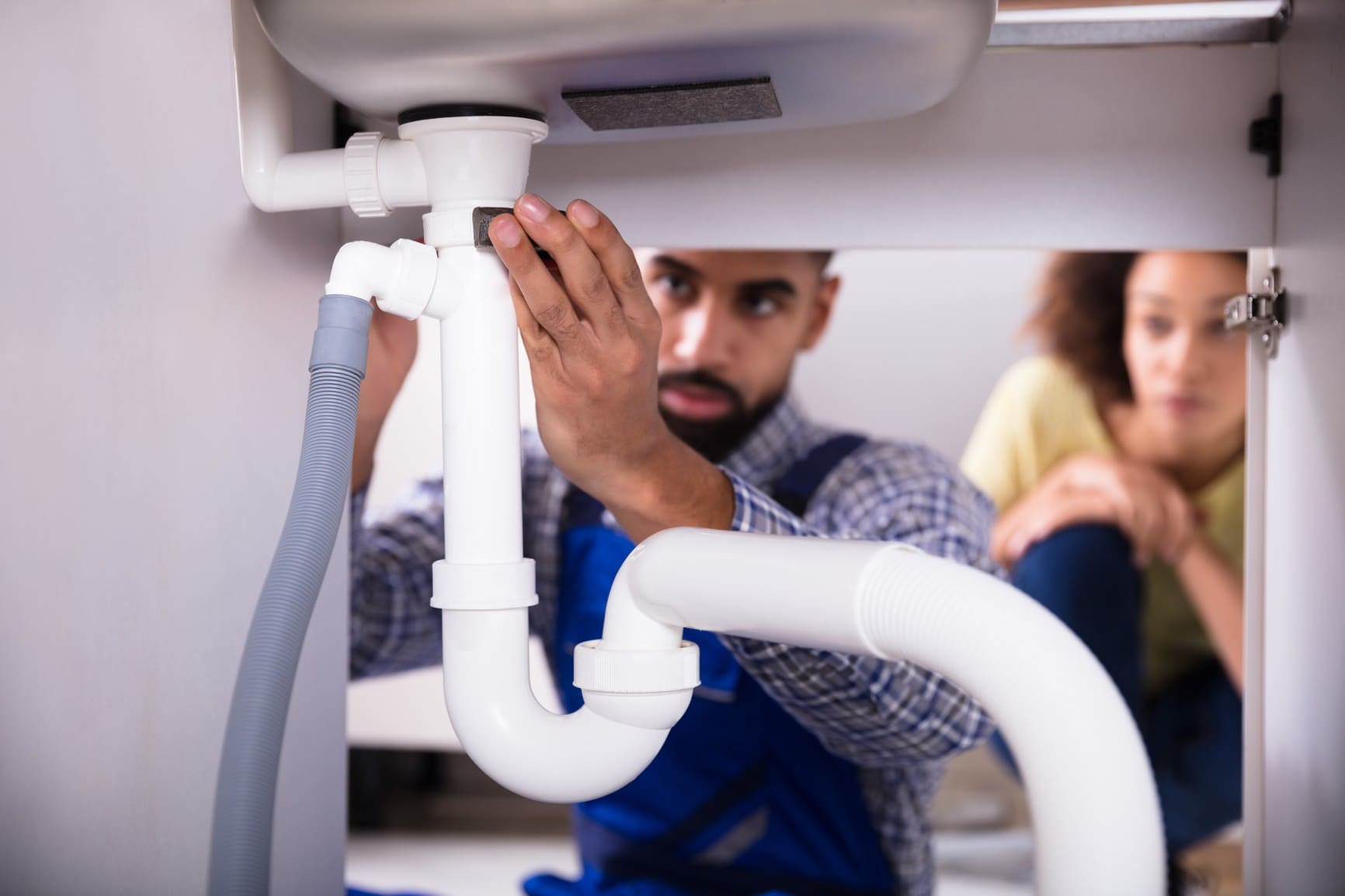 A Man and Woman Work Together to Repair a Sink Drain in Jacksonville, FL